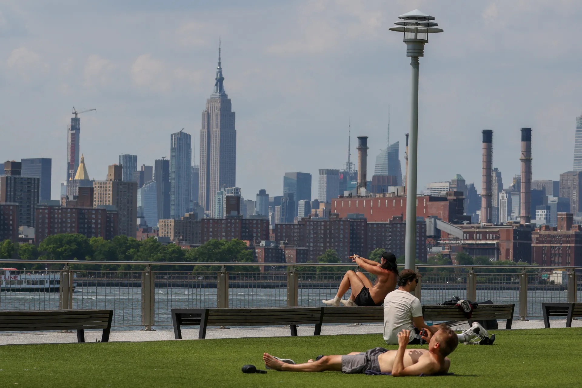La gente se acuesta al sol en Domino Park mientras la temperatura se acerca a los 94 grados Fahrenheit (34.44 Celsius), durante un aviso de calor en Brooklyn, Nueva York. EFE/EPA/Sarah Yenesel