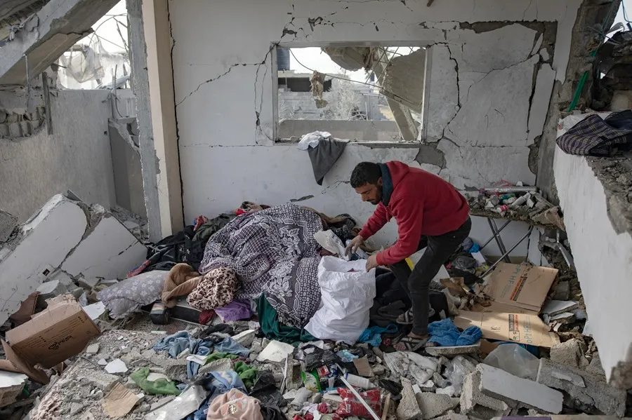 Un palestino inspeccionaba su casa tras un ataque aéreo israelí, en el campo de refugiados de Rafah, en el sur de la Franja de Gaza, el pasado 26 de marzo. EFE/EPA/Haitham Imad