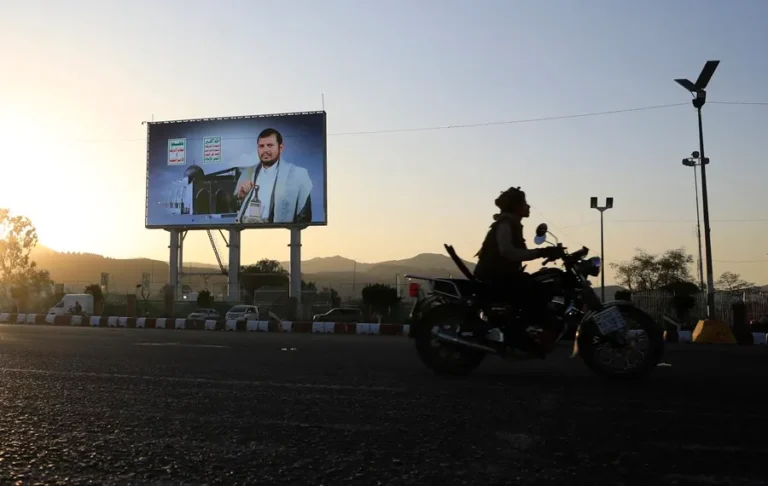 Un motociclista pasa junto a un cartel con la imagen del máximo líder de los hutíes, Abdul-Malik al-Houthi, en Saná. EFE/EPA/Yahya Arhab
