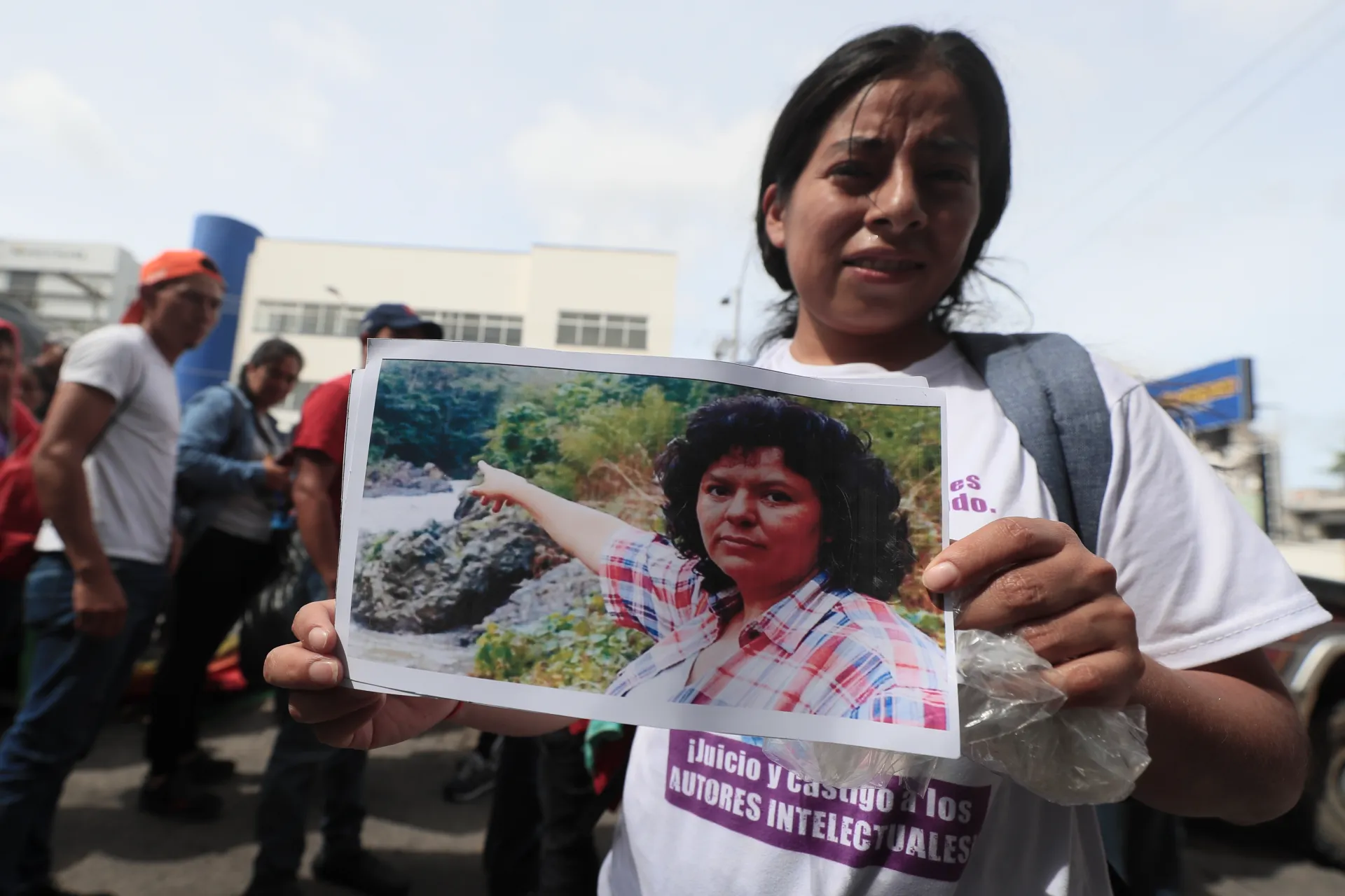 Una mujer miembro del Consejo Cívico de Organizaciones Populares e Indígenas de Honduras (Copinh) sostiene un retrato de la ambientalista hondureña Berta Cáceres, asesinada en 2016, frente al Juzgado de Sentencia en Tegucigalpa (Honduras). EFE/ Gustavo Amador