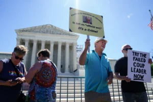 Un hombre muestra un mensaje en contra de la inmunidad de Donald Trump, afuera del Tribuanl Supremo de EE.UU., este 1 de julio de 2024, en Washington. EFE/Will Oliver