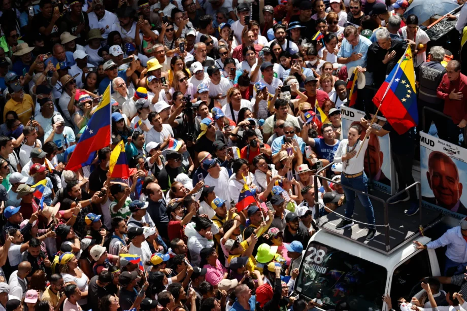 La líder de la oposición venezolana María Corina Machado (d) agita la bandera de Venezuela frente a seguidores este sábado, en Caracas (Venezuela). EFE/ Miguel Gutiérrez