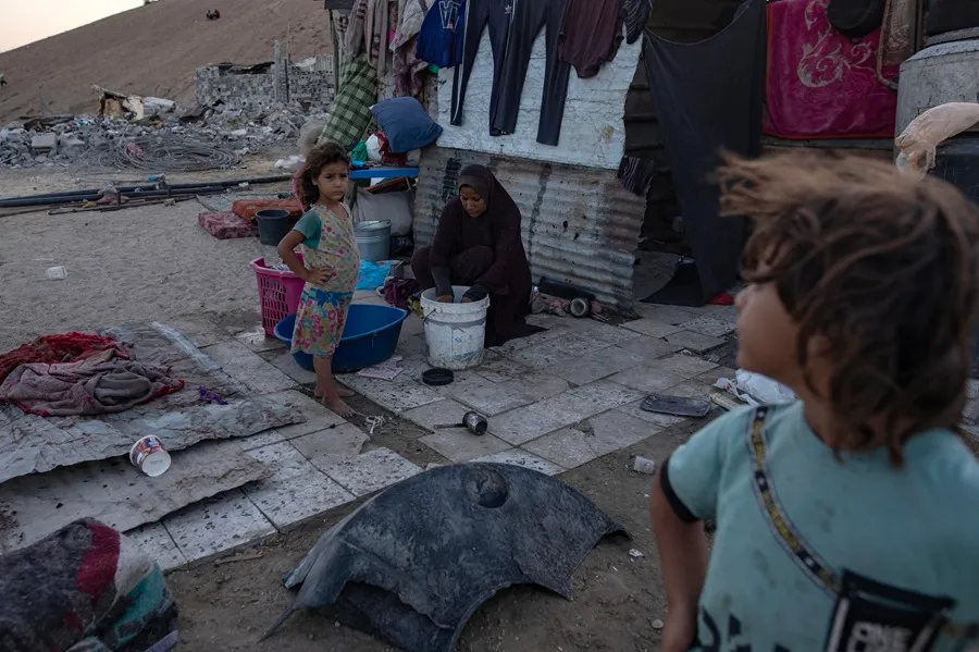 Una mujer palestina desplazada lava ropa en un campamento improvisado construido entre los escombros en Jan Yunis. EFE/EPA/Haitham Imad