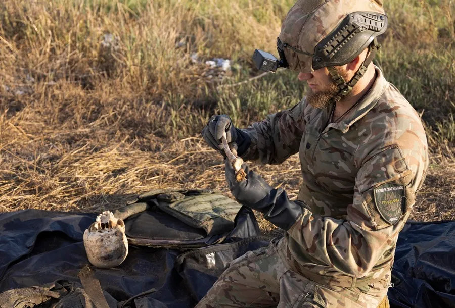 Miembros del grupo de búsqueda ‘Platsdarm’ de Ucrania trabajan en la exhumación e identificación de los cuerpos de militares rusos muertos cerca de una línea de frente en el área de Bakhmut, región de Donetsk, Ucrania. EFE/EPA/Nikoletta Stoyanova