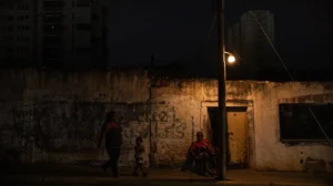 Un hombre descansa bajo un poste de luz, el 29 de febrero de 2024, en Maracaibo (Venezuela), tras un apagón. EFE/ Henry Chirinos