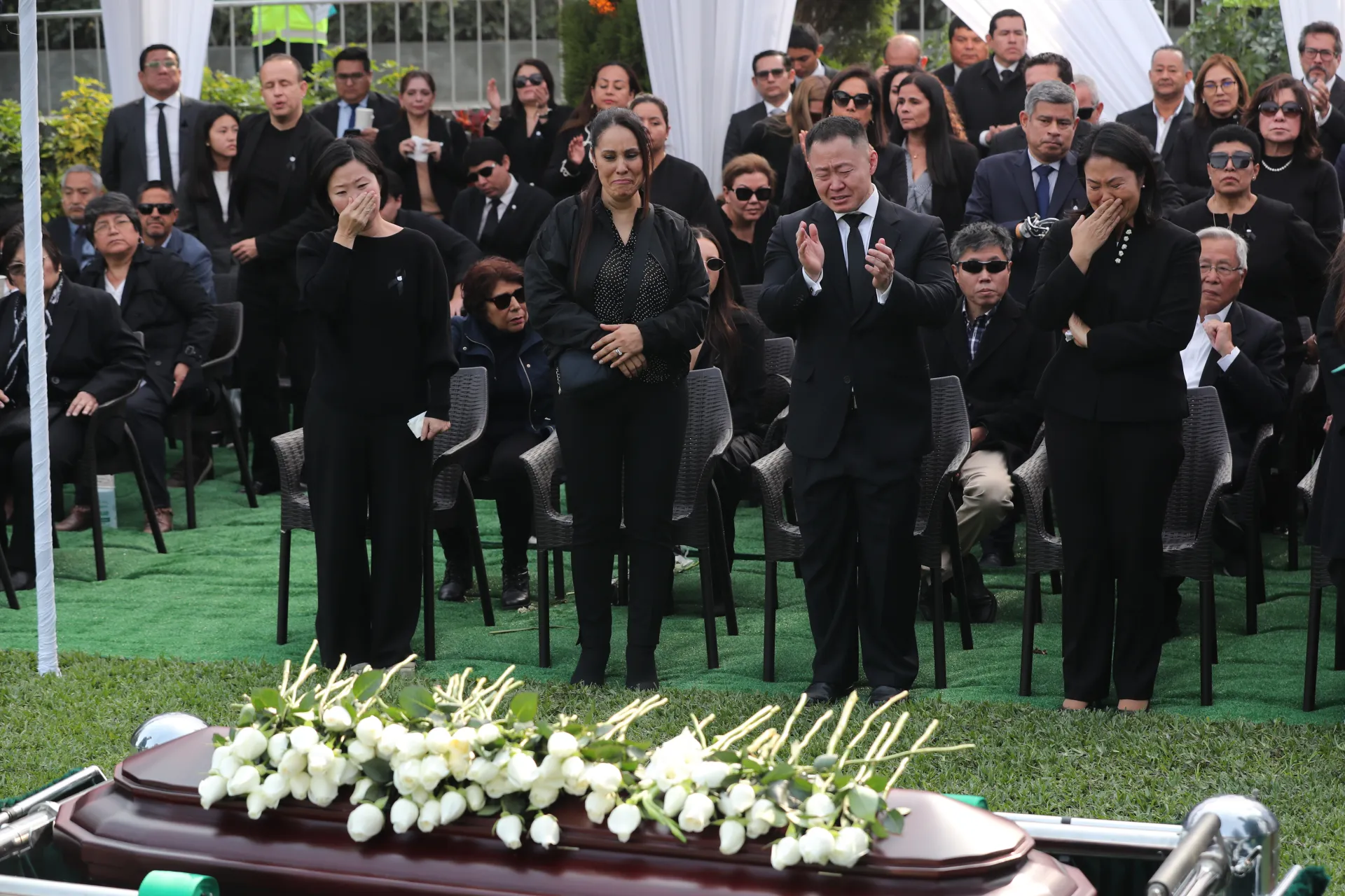 Kenji (2d), Sachi (i) y Keiko Fujimori (d) lloran durante el funeral de su padre, el expresidente de Perú, Alberto Fujimori, en el cementerio Huachipa en Lima (Perú). EFE/Paolo Aguilar