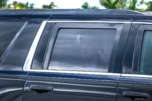 El expresidente estadounidense Donald Trump saluda con la mano por la ventanilla trasera mientras su comitiva se dirige al Aeropuerto Internacional de West Palm Beach, Florida (EE.UU.). EFE/Cristóbal Herrera-Uláshkevich