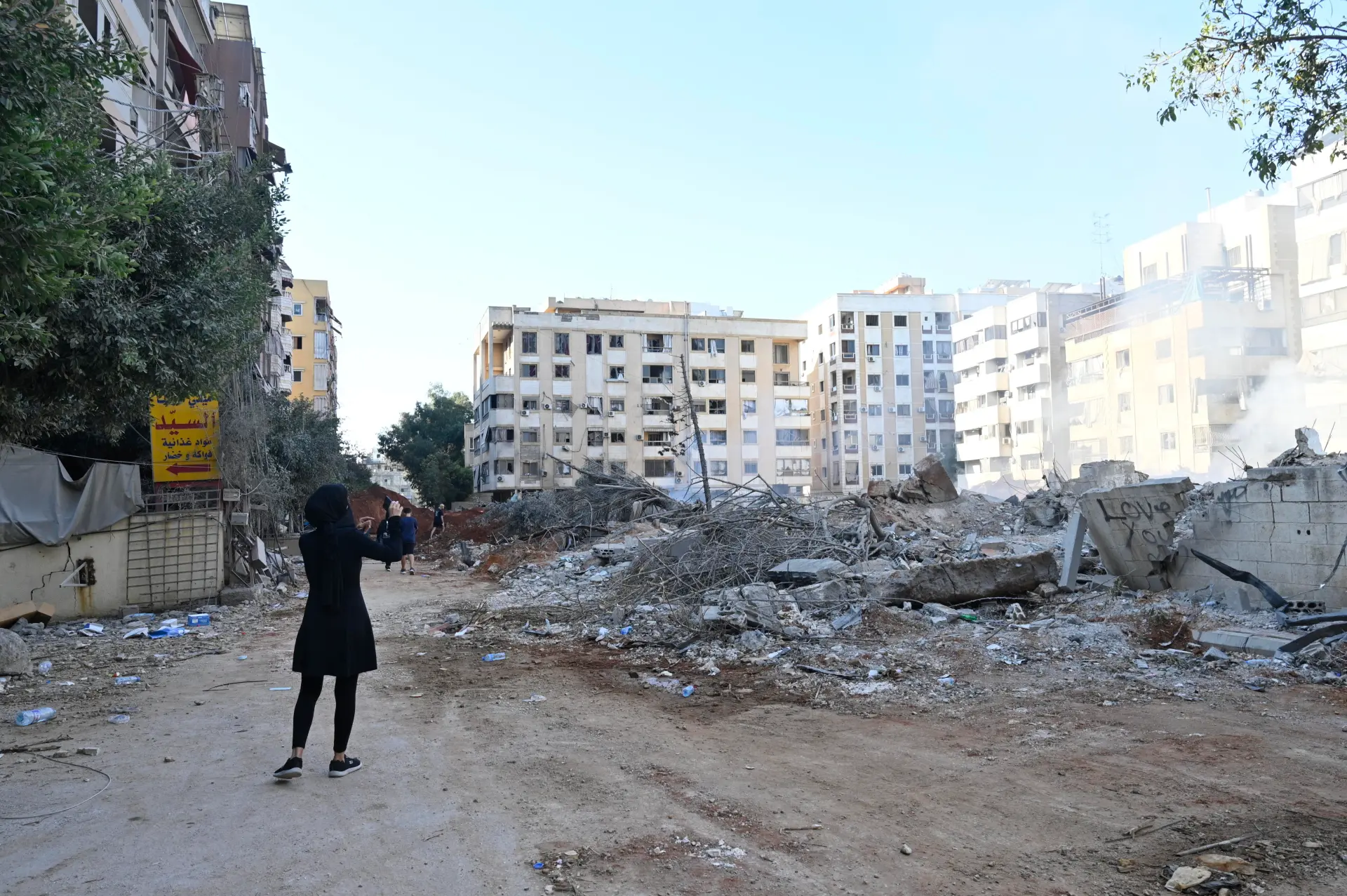 Una mujer se encuentra junto a edificios destruidos en el barrio de Haret Hreik, en los suburbios del sur de Beirut (Líbano). EFE/Wael Hamzeh