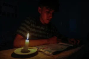 Fotografía de archivo de un estudiante lee un texto a la luz de una vela en Quito (Ecuador). EFE/José Jácome