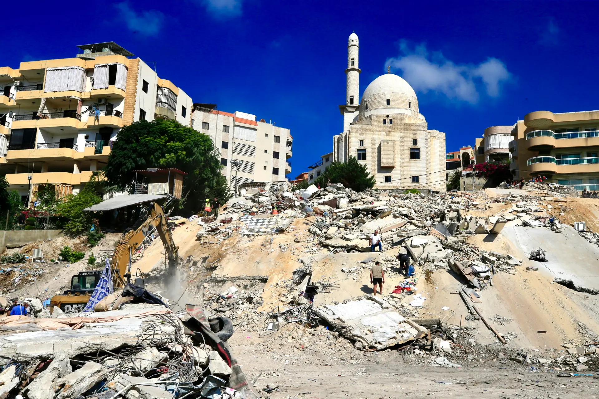 Miembros de un equipo de búsqueda y rescate, junto con residentes locales, trabajan para encontrar cadáveres bajo los escombros de los edificios destruidos en un ataque aéreo israelí en el barrio de Ain el-Delb, al este de la ciudad portuaria de Sidón (Líbano). EFE/-