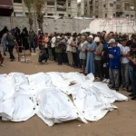 Familiares y allegados rezan ante víctimas de un ataque aéreo israelí en el campo de refugiados de Jan Yunis, en el sur de la Franja de Gaza. EFE/EPA/Haitham Imad