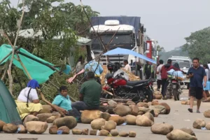 Personas caminan en medio de piedras que bloquean una vía durante la tercera jornada de protestas por parte de seguidores de Evo Morales, este miércoles en Puente Ichilo, Santa Cruz, (Bolivia). EFE/Juan Carlos Torrejon