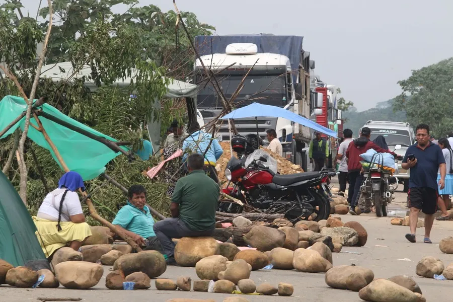 Personas caminan en medio de piedras que bloquean una vía durante la tercera jornada de protestas por parte de seguidores de Evo Morales, este miércoles en Puente Ichilo, Santa Cruz, (Bolivia). EFE/Juan Carlos Torrejon