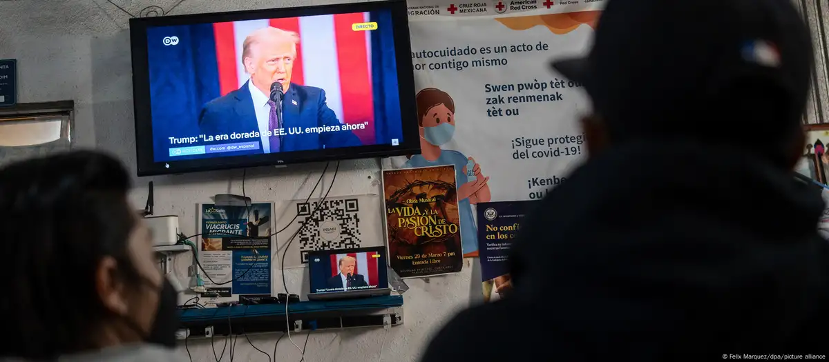 Migrantes siguen el discurso de asunción del cargo de Donald Trump en Estados Unidos por televisión.