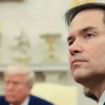El secretario de Estado de Estados Unidos, Marco Rubio. De fondo, Donald Trump.