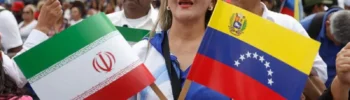 Una venezolana en una marcha en Caracas con la bandera de su país y la de Irán.